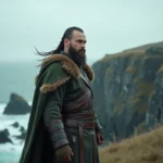 Guerrier viking en costume médiéval authentique se tenant debout sur une falaise rocheuse surplombant la mer, évoquant le personnage de Bjorn dans la série Vikings