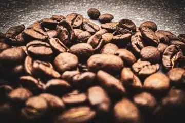 brown coffee beans on black surface