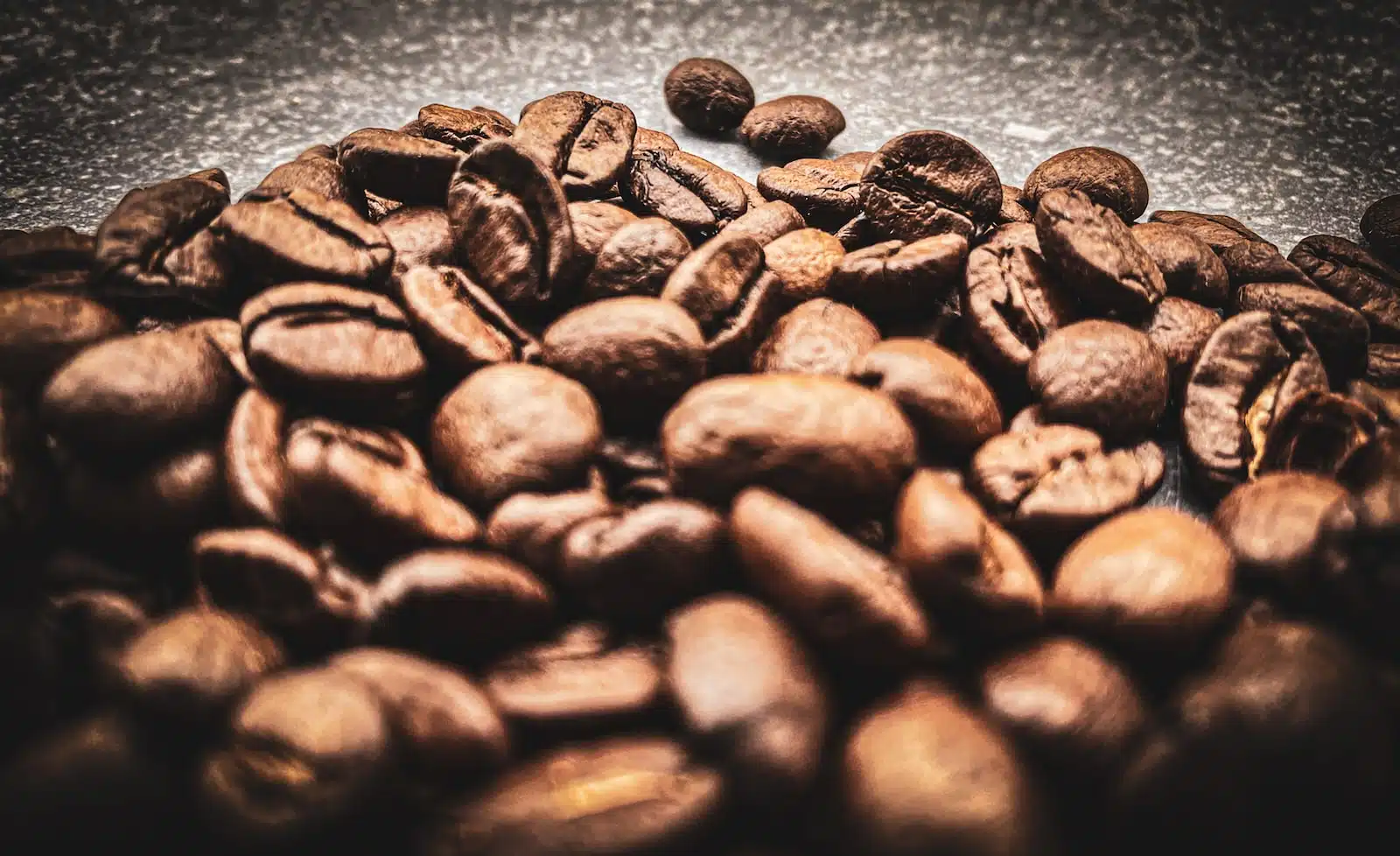 brown coffee beans on black surface