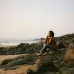 une femme assise en bord de mer